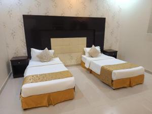 two beds in a hotel room with two bedsitures at Quiet Rooms 2 Serviced Apartments in Riyadh