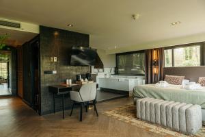 a bedroom with a bed and a bathroom with a tub at Van der Valk Hotel Apeldoorn - de Cantharel in Apeldoorn