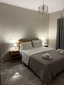 a bedroom with a bed with two towels on it at Hotspot Acharnes in Acharnes