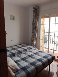 a bedroom with two beds and a window at La casa del abuelo in Ítrabo