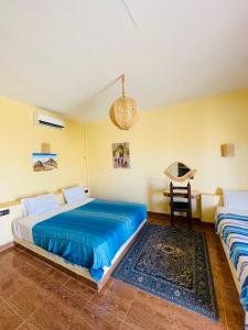 a bedroom with two beds and a table at Merzouga Hotel Activities in Merzouga +72 photos