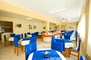 a restaurant with blue chairs and tables and a bar at Pousada Vale Del Sol in Bombinhas