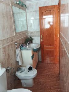 a bathroom with a toilet and a sink and a mirror at La casa del abuelo in Ítrabo +2 photos
