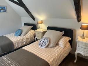 a bedroom with two beds and two night stands at L'Ancienne Boulangerie in Collinée