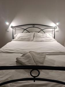 a bed with white sheets and pillows on it at Arcadia Hosting Piazza XX Settembre in Bologna