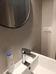a bathroom sink with a faucet and a mirror at Arcadia Hosting Piazza XX Settembre in Bologna