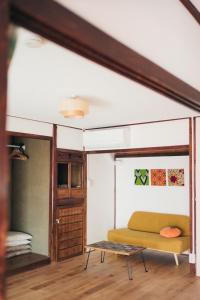 a room with a couch and a table at 離島の宿 Nawanawa Backpackers in Matsuyama