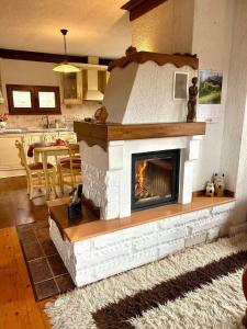 a living room with a fireplace in the middle of it at Родопски Рай in Slaveino +25 photos