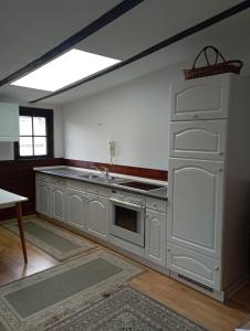 a kitchen with white cabinets and a sink at Ferienwohnung Vogelnest in Templin
