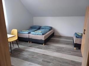a room with two beds and a table and a chair at Agroturystyka W Stadninie Koni in Maszyce +4 photos
