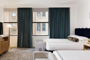 a hotel room with a bed and some windows at Kimpton Hotel Monaco Philadelphia by IHG in Philadelphia