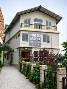 a hotel building with a sign that reads hotel old believer hotel and gate at Hotel Old Bellevue Heritage Stay with Mountain Views in Chowrasta Darjeeling in Darjeeling