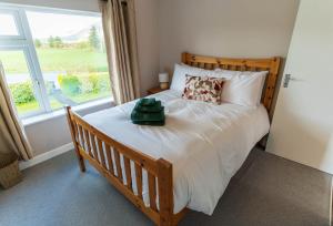 a bedroom with a bed with a large window at Greenway Riverside House - Cahersiveen in Foilmore Bridge