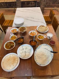 a wooden table with many plates of food on it at GroveStay in Chakkarakkal