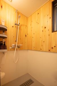 a shower in a bathroom with wooden walls at 離島の宿 Nawanawa Backpackers in Matsuyama +59 photos