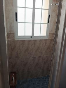 a bathroom with a shower with a window in it at La casa del abuelo in Ítrabo