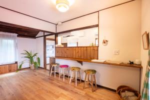 a room with two bar stools and a counter at 離島の宿 Nawanawa Backpackers in Matsuyama