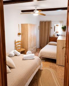 a bedroom with two beds and a ceiling fan at Casa del Agua- Casa rural con encanto en Sierra Nevada terraza y chimenea in Abrucena