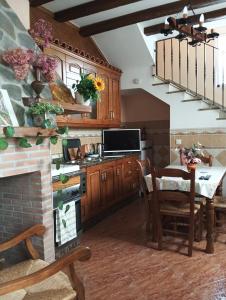a kitchen with wooden cabinets and a table with a dining room at La casa del abuelo in Ítrabo