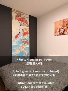 a bedroom with a painting on the wall and a bed at 登福桜 動物園前駅4番出口徒歩1秒 通天閣5分 難波駅10分 大阪駅15分 関西空港直通 usj25分 in Osaka