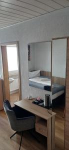 a room with a desk and a bed and a mirror at Hotel Birnbaum in Ansbach