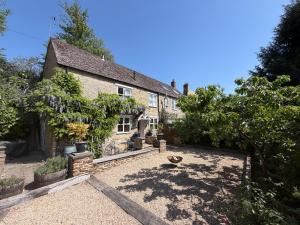 a house with a courtyard in front of it at Cotswold Cottage in Steeple Aston