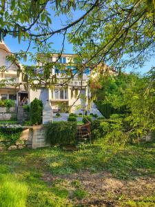 a house with a bench in the yard at Vila Riverside Nikolaj in Niš