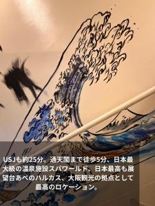 a painting of a wave on a wall with chopsticks at 登福桜 動物園前駅4番出口徒歩1秒 通天閣5分 難波駅10分 大阪駅15分 関西空港直通 usj25分 in Osaka +71 photos