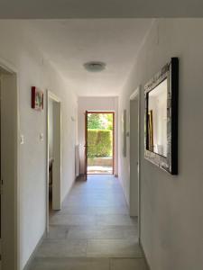 a hallway with white walls and a hallway with a doorway at Casa Martello in Levico Terme