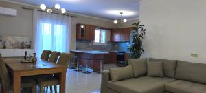 a living room and kitchen with a couch and a table at Golden rose in Corfu