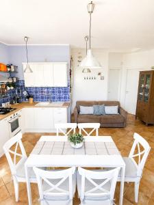 a kitchen and living room with a white table and chairs at Agave Scopello in Scopello +28 photos