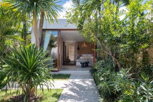 a house with a tropical garden with a courtyard at Private Oceanfront Villa Kingfisher - 20m Infinity Pool in Nusa Lembongan