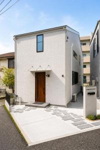 a white brick building with a brown door at 北鎌倉駅徒歩圏 観光便利 最大7名 2寝室 広々滞在 101 in Kamakura