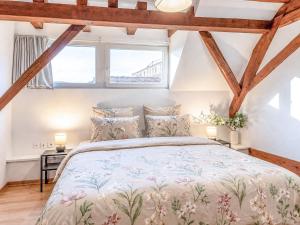 a bedroom with a large bed with wooden beams at Duplex 80m2 AC I Balcon Parking I Route des Vins in Marlenheim