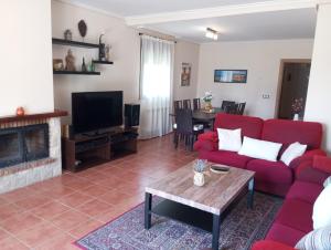 a living room with a red couch and a fireplace at Chalet independiente con vistas in Bustarviejo