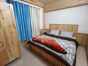 a bedroom with a bed with red pillows on it at Chander Guest House in Kasol