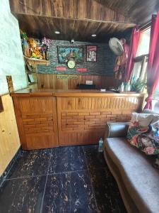 a kitchen with a bar with a couch in a room at Chander Guest House in Kasol