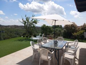 a patio with a table and chairs and an umbrella at Chalet independiente con vistas in Bustarviejo