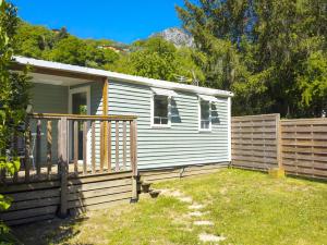 a small white house with a fence in a yard at Camping 3* Les Templiers in Roquebillière