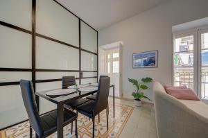 a dining room with a table and chairs and a couch at The Secret - R5 in Senglea