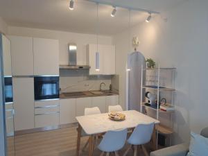 a white kitchen with a table and chairs at Brezza d'amare a lovely accommodation in Anzio in Anzio