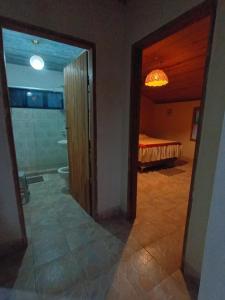 a hallway with a room with a bed and a bathroom at Ecoturismo Tripuí in Aiuruoca