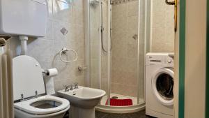 a bathroom with a toilet sink and a washing machine at A Due Onde, Viola Mare in Alassio