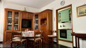 a kitchen with wooden cabinets and a table with chairs at A Due Onde, Viola Mare in Alassio