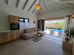 a living room with a couch and a television at Emma Luxury Pool Suites Resort in Willemstad