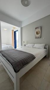 a large white bedroom with a large white bed at Ippokampos in Moutsoúna