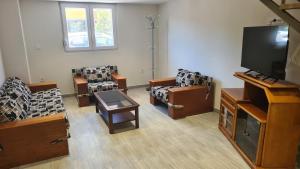 a living room with chairs and a flat screen tv at JP Luxury Apartment 2 in Chios