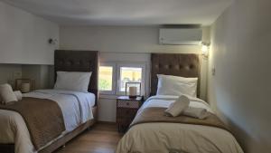 a bedroom with two beds and a window at JP Luxury Apartment 2 in Chios