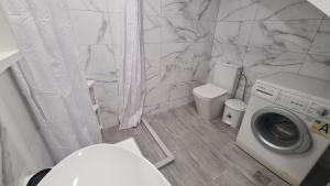 a bathroom with a washing machine and a toilet at JP Luxury Apartment 2 in Chios +10 photos