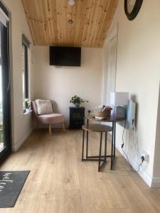 a living room with a table and a tv on the wall at Sky View Cabin in Ardaghy